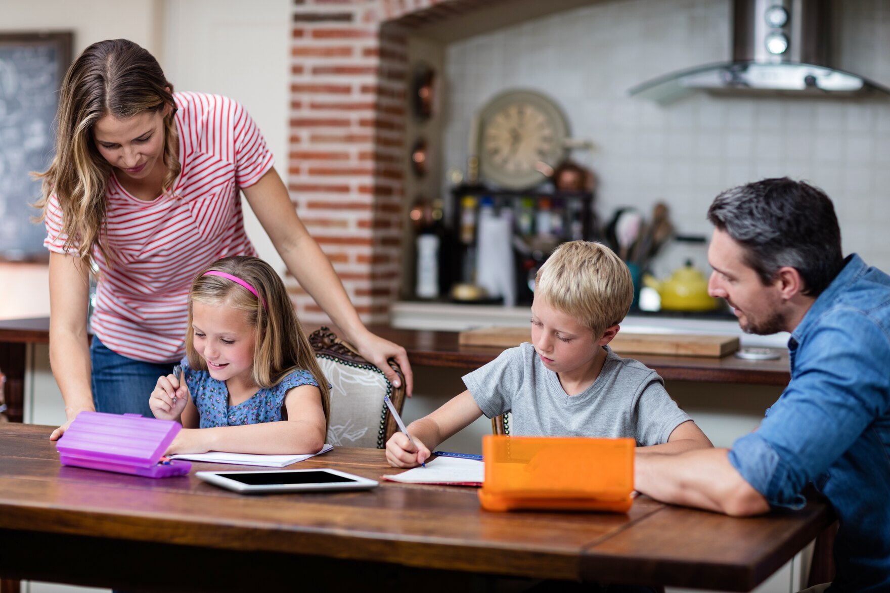 Familie am Küchentisch macht Hausaufgaben